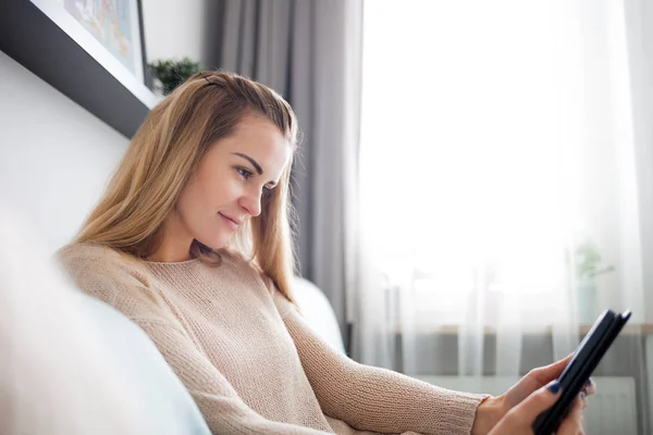 Šťastná Žena Čtení Ebook Digitální Čtečka Vleže Pohodlném Gauči Doma — Stock fotografie