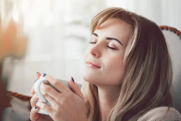 愉快的女人在柔软的毛衣放松在家里与一杯热茶或咖啡 积极的情绪 — 图库照片
