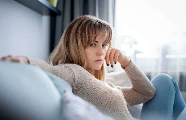 Mujer Deprimida Sentada Sofá Casa Mirando Tristemente Cámara Pensando Cosas — Foto de Stock