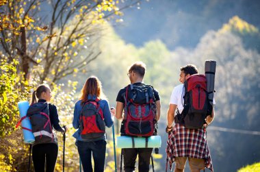 Sırt çantaları ve trekking çubukları ile yürüyüş turist gezisinde arkadaş Otantik grup
