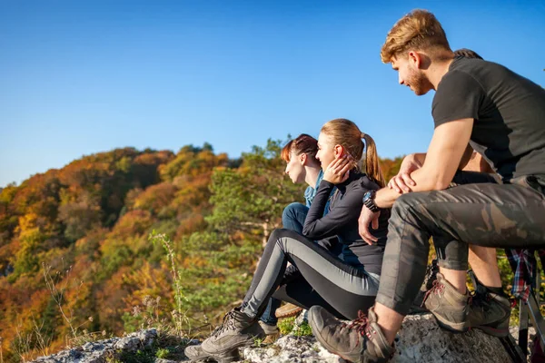 一群游客坐在岩石上 在山上徒步旅行后休息 — 图库照片