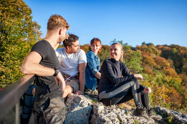 岩の上に座って 山でトレッキングした後に休む旅行者のグループ — ストック写真