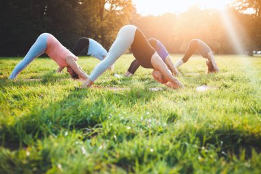 Parkta dışarıda yoga yapan insanların karışık yaş grubu