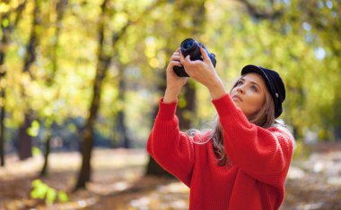 Genç kadın fotoğrafları yeşil park yapma kamera ile eğleniyor