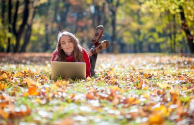 Güzel gülümseyen kadın dizüstü çim üzerinde yalan açık kullanma