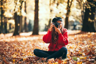 Genç kadın fotoğrafları yeşil park yapma kamera ile eğleniyor