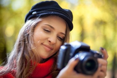 Genç kadın fotoğrafları yeşil park yapma kamera ile eğleniyor