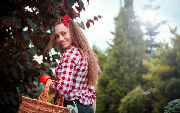 ツールと彼女の庭でガーデニングに行く若い庭師女性 — ストック写真