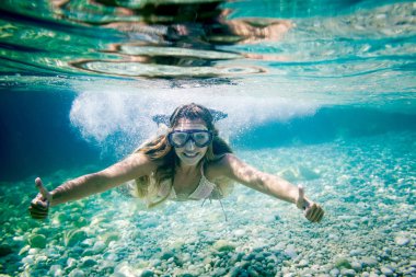 Tropikal deniz şnorkel, kadın başparmak tabela su altında gösterir