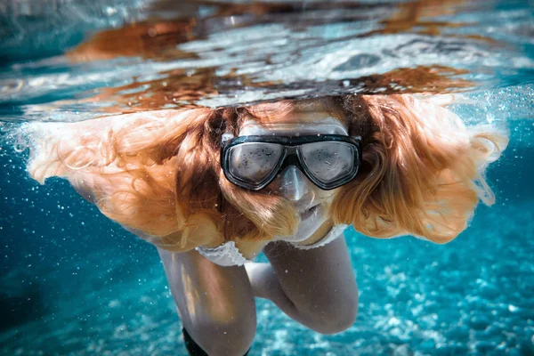 Beautiful woman with long hair underwater portrait in the tropical sea