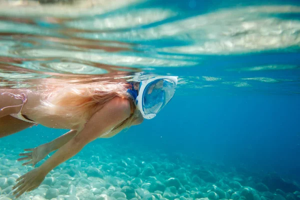 Woman snorkeling with full face mask in the tropical sea