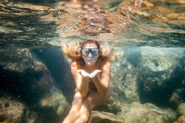 若い女性の熱帯の海で水中の岩の近くでシュノーケ リング — ストック写真
