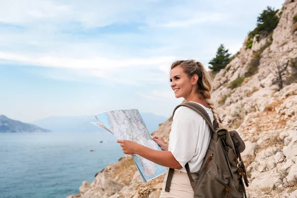 徒步旅行的女孩背包和地图徒步旅行沿海湾的小道和看风景 — 图库照片