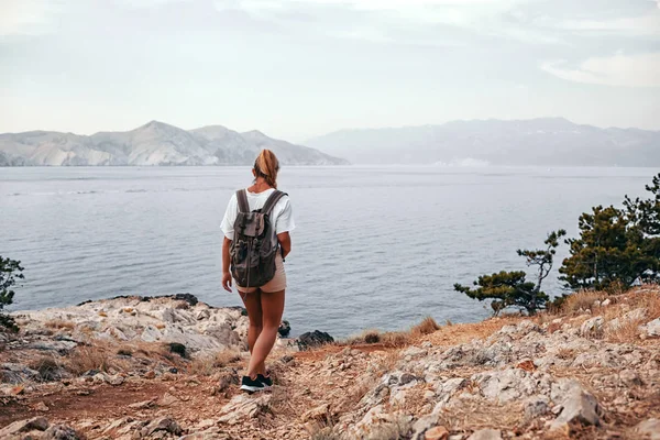 徒步旅行的女孩与背包徒步旅行沿海湾的小道 — 图库照片