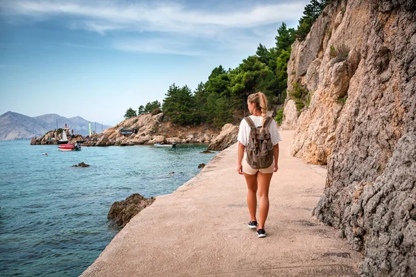 背着背包沿着海边散步的旅游妇女 在旅行中发现 — 图库照片
