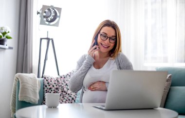 Evde laptop ile online çalışan hamile kadın, konsept freelancing