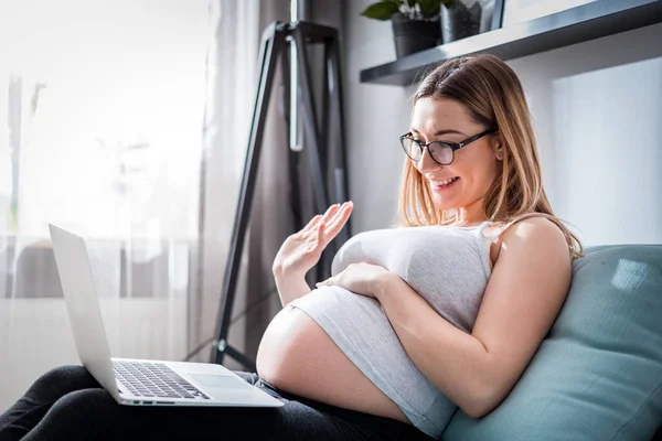 Schwangere plaudert mit Familie auf Laptop und winkt mit der Hand zum Bildschirm — Stockfoto