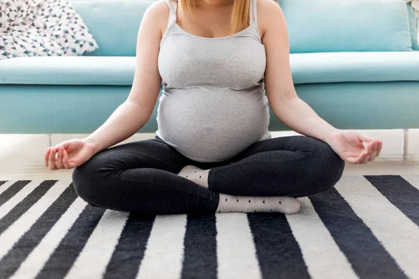 Méditer sur la maternité, femme enceinte méditer assis sur le tapis à la maison — Photo