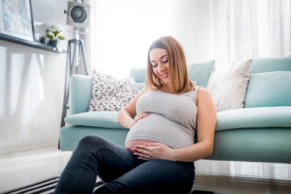 Schöne Lächelnde Schwangere Die Hause Auf Dem Boden Sitzt Den — Stockfoto