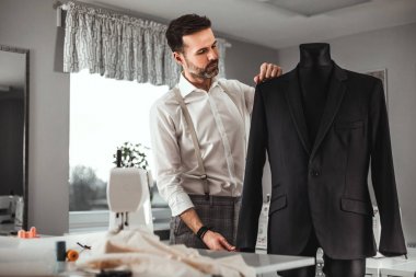 Moda tasarım atölyesinde manken üzerinde Terzi ölçüm ceket takım