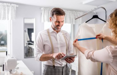 Moda tasarım stüdyosunda dijital tablet kullanarak proje çalışmaları sırasında profesyonel terziler
