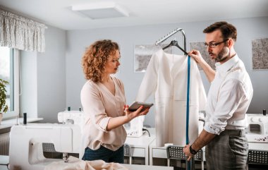 Moda tasarım stüdyosunda dijital tablet kullanarak proje çalışmaları sırasında profesyonel terziler
