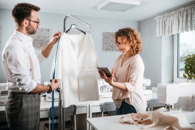 Moda tasarım stüdyosunda dijital tablet kullanarak proje çalışmaları sırasında profesyonel terziler