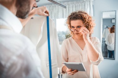 Moda tasarım stüdyosunda dijital tablet kullanarak proje çalışmaları sırasında profesyonel terziler