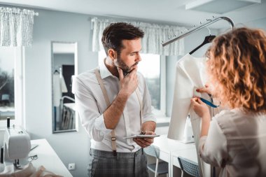 Moda tasarım stüdyosunda dijital tablet kullanarak proje çalışmaları sırasında profesyonel terziler