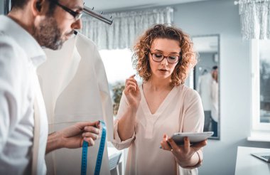 Moda tasarım stüdyosunda dijital tablet kullanarak proje çalışmaları sırasında profesyonel terziler