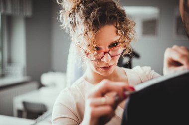 Moda tasarım stüdyosunda dikiş takım elbise için müşteri ölçmek için bant kullanarak profesyonel terzi