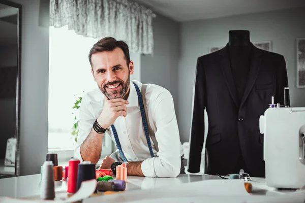 Tailor shop owner over work desk, craftsman in sewing workshop