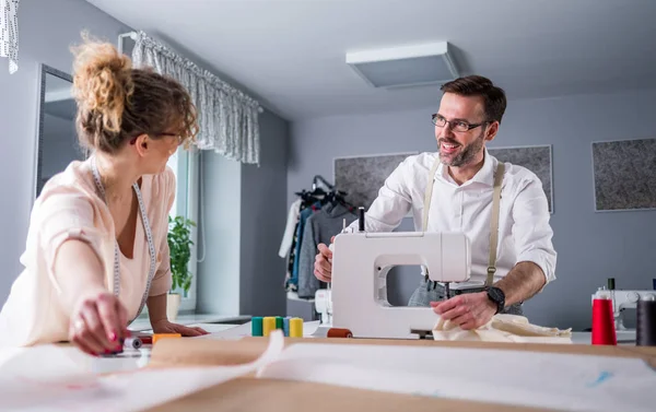 Moda tasarım stüdyosunda dikiş makinesi kullanarak proje çalışmaları sırasında profesyonel terziler
