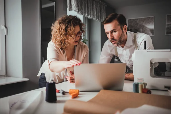 Professionelle Schneider bei der Arbeit am Projekt mit Laptop im Modedesign-Studio — Stockfoto