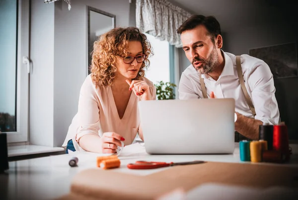 Moda tasarım stüdyosunda dizüstü bilgisayar kullanarak proje çalışmaları sırasında profesyonel terziler