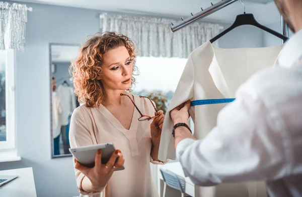 Moda tasarım stüdyosunda dijital tablet kullanarak proje çalışmaları sırasında profesyonel terziler