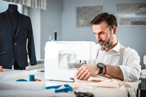 Tailleur travaillant avec une machine à coudre à l'atelier de design de mode Images De Stock Libres De Droits