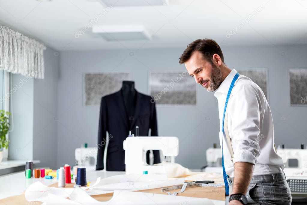 Tailor over work desk during work, fashion designer at workshop