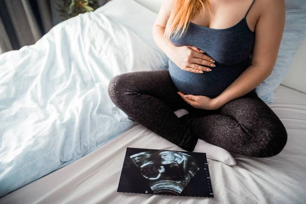 Těhotná Žena Seděla Posteli Dívala Ultrazvukovou Fotografii Svého Dítěte — Stock fotografie