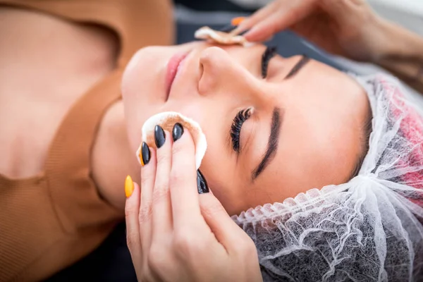 Beautician cleanses skin woman with sponge in spa beauty salon. cosmetology treatment skincare face