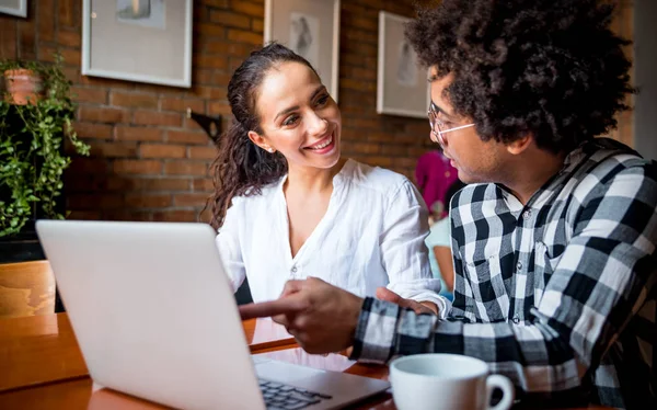 Multiethnic people meeting at cafe, advisor showing offer to client on laptop