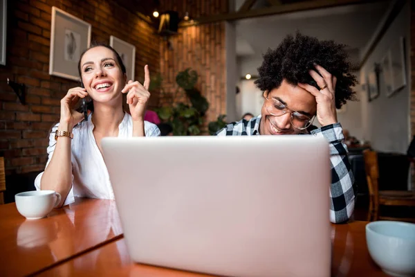 Reunión del equipo de negocios multiétnicos en la cafetería, trabajando con computadora portátil y teléfono inteligente — Foto de Stock