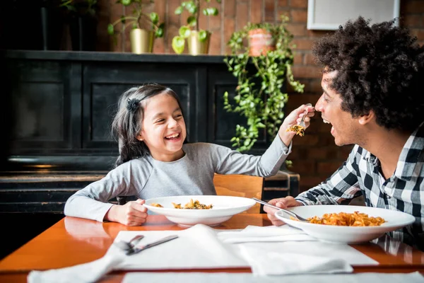 Latinský otec a dcera jedí spolu oběd v restauraci, multietnická rodina se baví — Stock fotografie