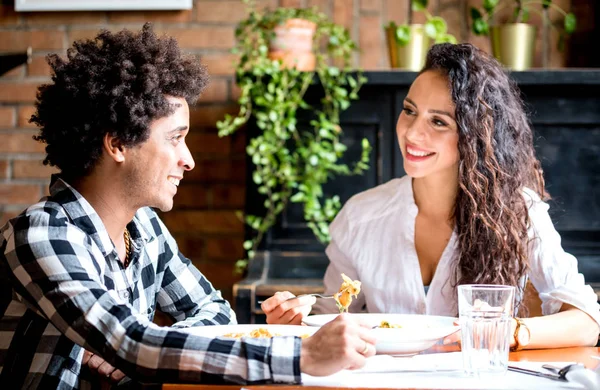 Счастливая молодая пара обедает вместе в ресторане, африканские американцы веселятся — стоковое фото