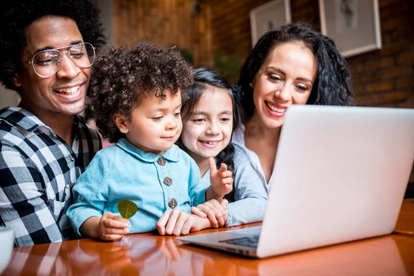 Boldog többnemzetiségű család birtoklás móka rövid idő használ laptop együtt — Stock Fotó