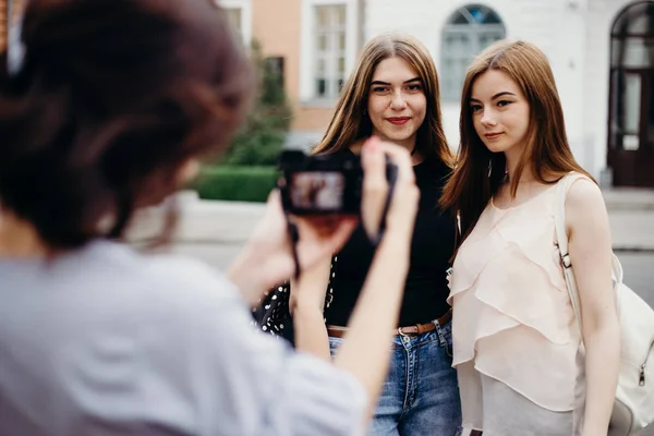 Mujer tomar foto de amigos en el fondo de la ciudad — Foto de Stock