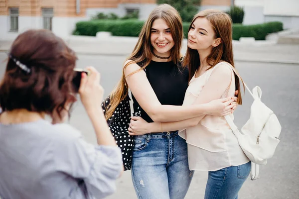 Mujer fotografiando a sus amigos en el fondo de la ciudad — Foto de Stock