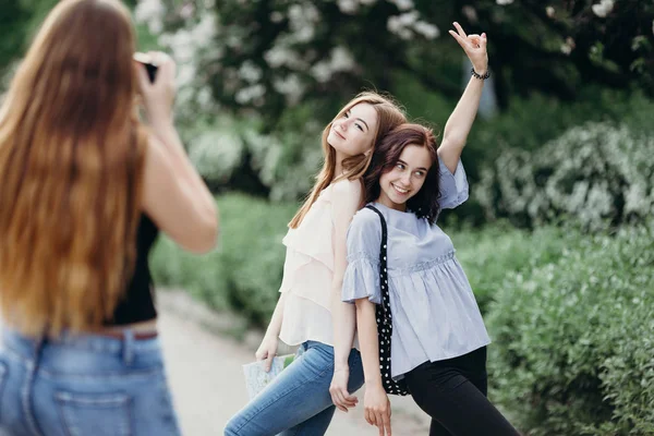 Mulher tirando foto de seus amigos usando a câmera — Fotografia de Stock