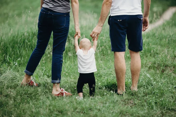 Familia feliz de mamá, papá y su hija caminan al aire libre —  Fotos de Stock