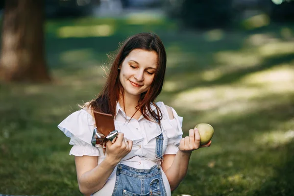 Kobieta w ciąży wybrać między apple i czekolada — Zdjęcie stockowe